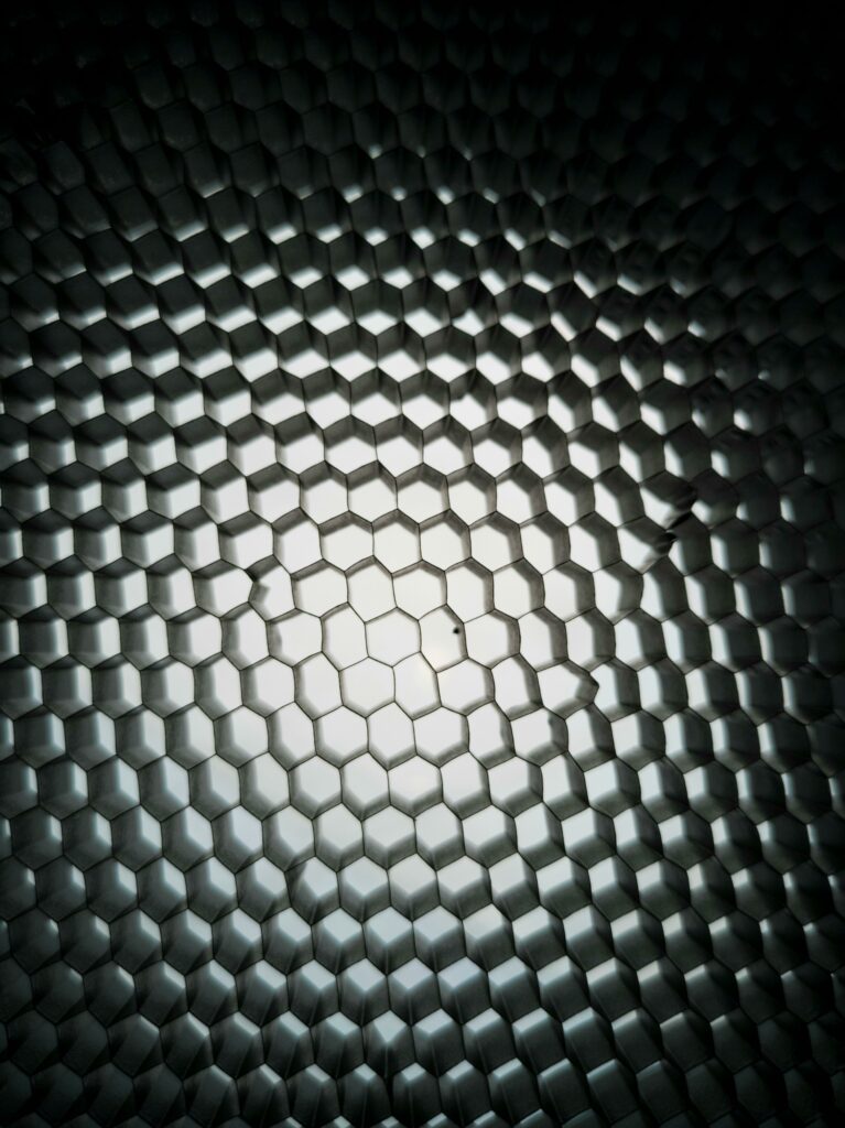 Dynamic geometric honeycomb pattern with metallic texture and gradient lighting.