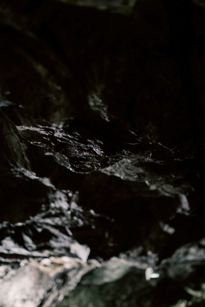 Explore the intricate textures of an ancient cave with stunning rock formations captured in ambient light.